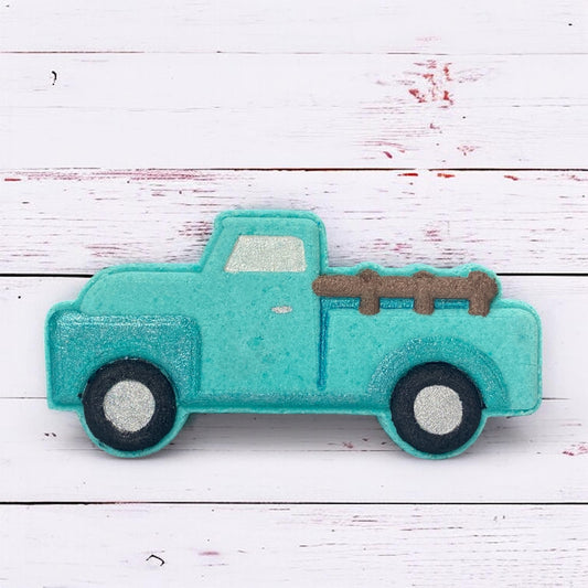 Turquoise toy truck with a brown bed on a white wooden surface
