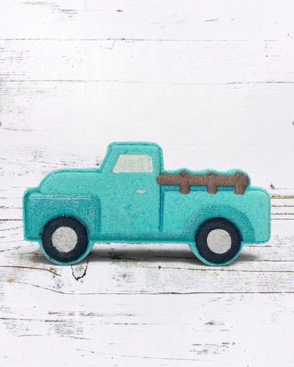 Turquoise toy truck with a brown bed on a white wooden surface