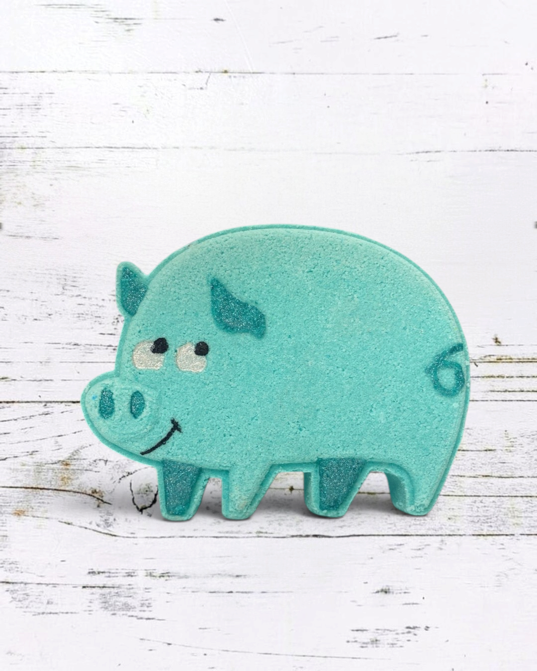 Teal pig-shaped bath toy on a white wooden background