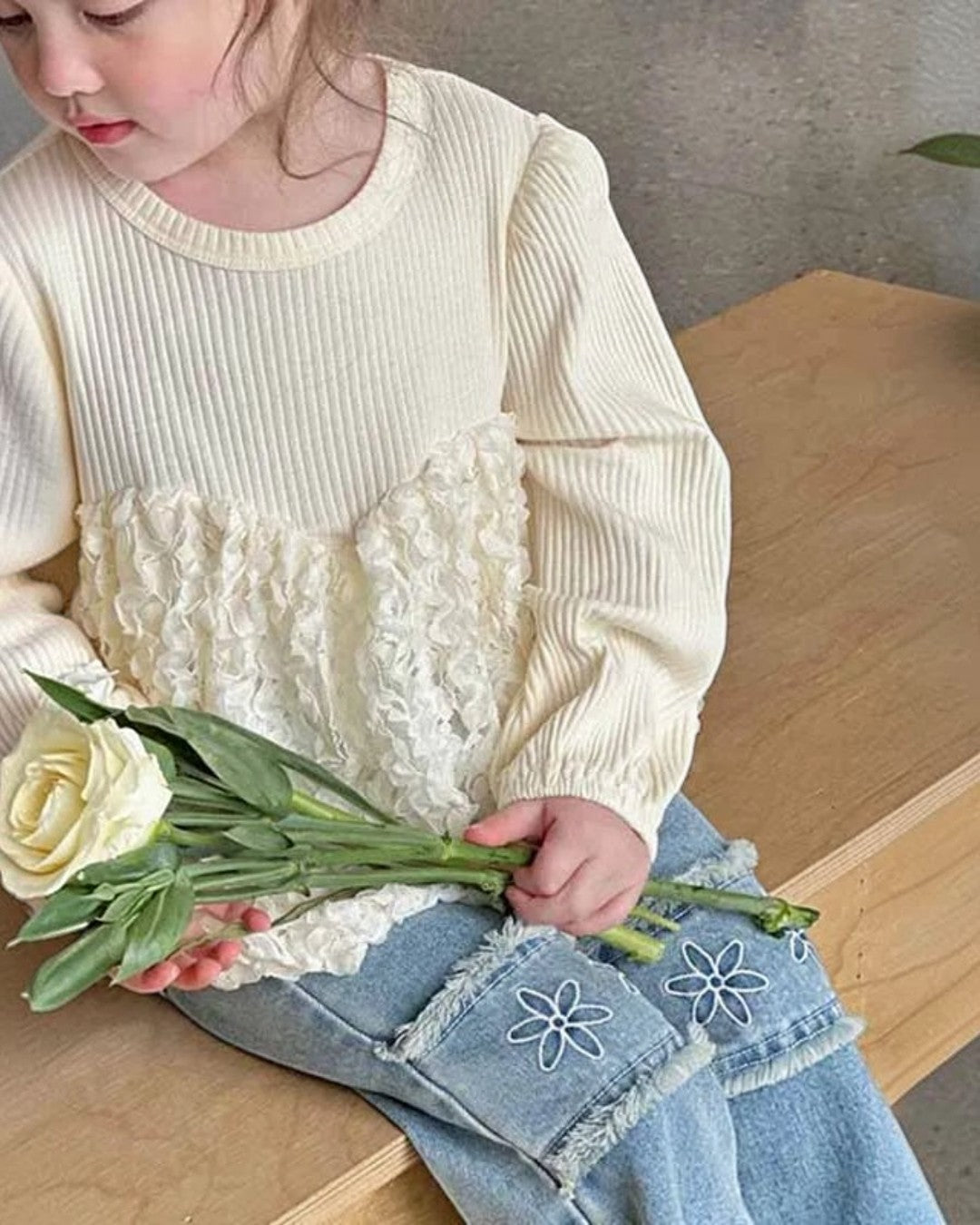 Child holding flowers in a home setting