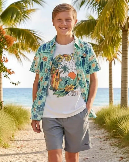 Young boy standing on a beach path with palm trees and ocean in the background
