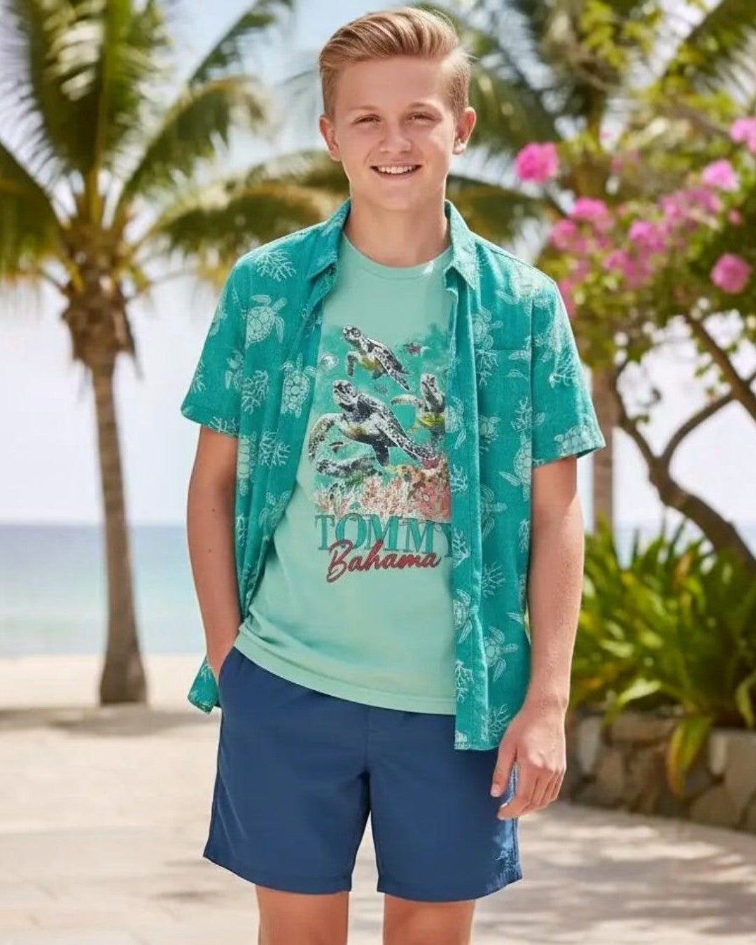 Young boy wearing a Tommy Bahama shirt on a tropical beach