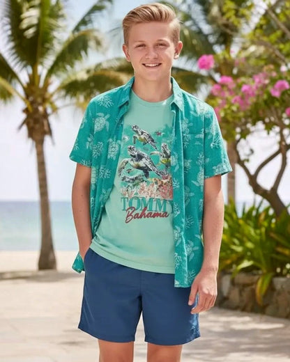 Young boy wearing a Tommy Bahama shirt on a tropical beach