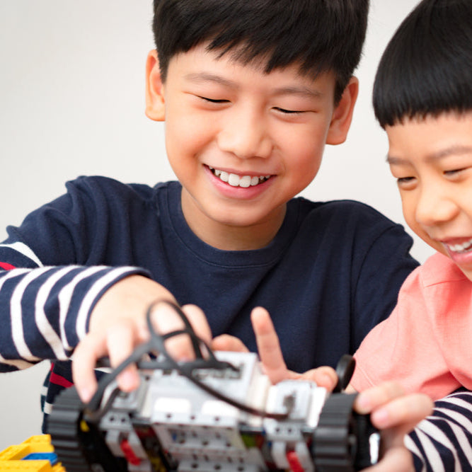 Two children playing with a toy car, smiling and engaged.