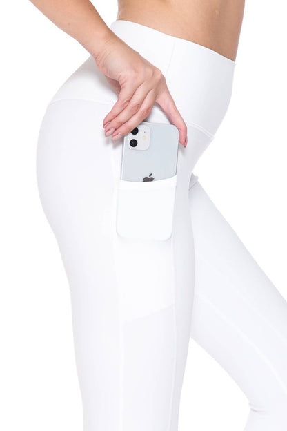 Person wearing white leggings with a phone in the pocket on a white background