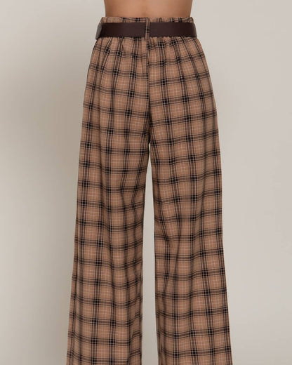 A pair of high-waisted, wide-leg trousers in a brown and beige plaid pattern, featuring a matching dark brown belt, shown on a model from the waist down against a neutral studio background.