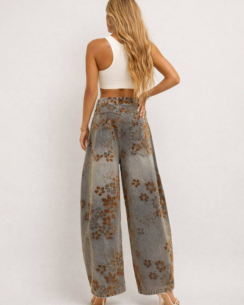 Woman wearing floral wide-leg jeans on a white background