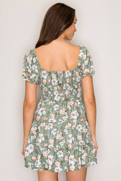 Woman wearing a floral dress against a plain background