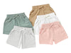 Five pairs of shorts in different colors on a white background