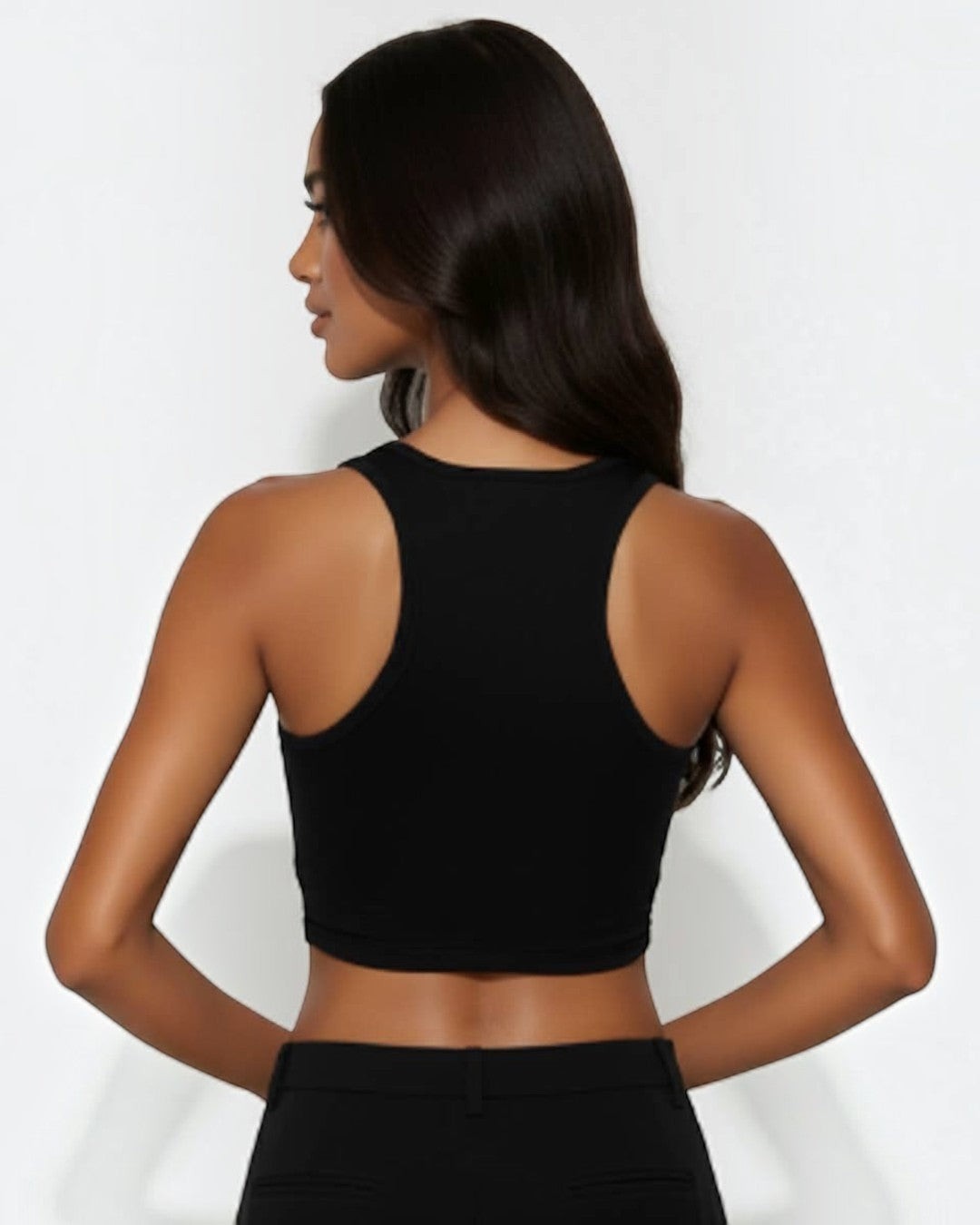 Woman wearing a black sleeveless top against a white background