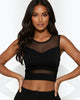 Woman wearing a black sheer top against a white background