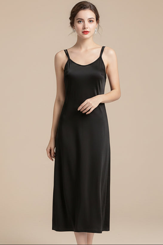 Black slip dress on a hanger against a white background