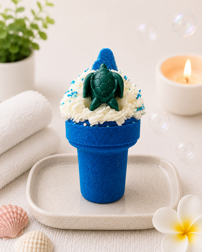 Blue cupcake with turtle decoration on a white surface with a candle and plant in the background