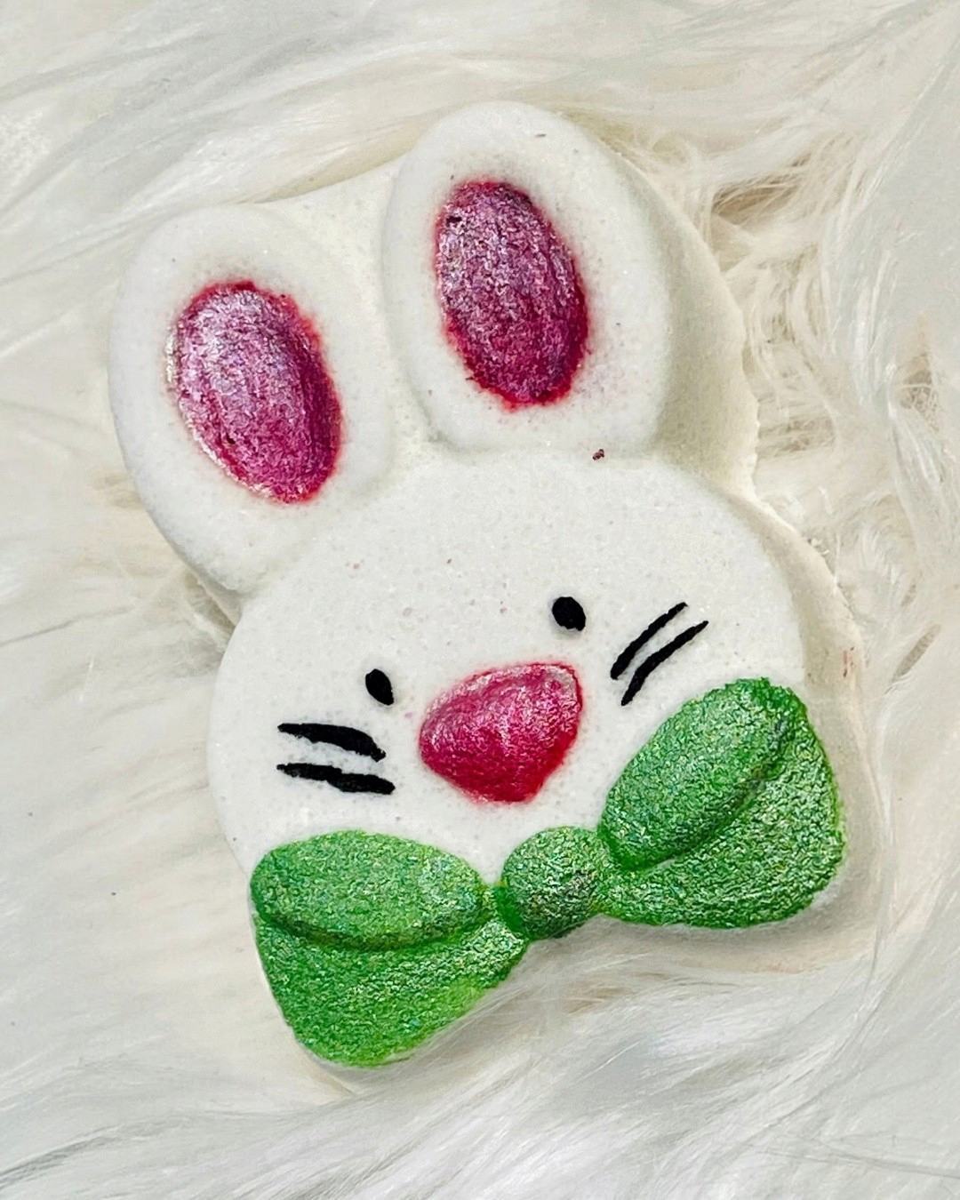 Calla Lily Cosmetics + CL kids white bunny bath bomb with pink ears, pink nose, and a sparkly green bow tie.
