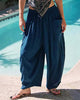 Person wearing blue harem pants by a pool