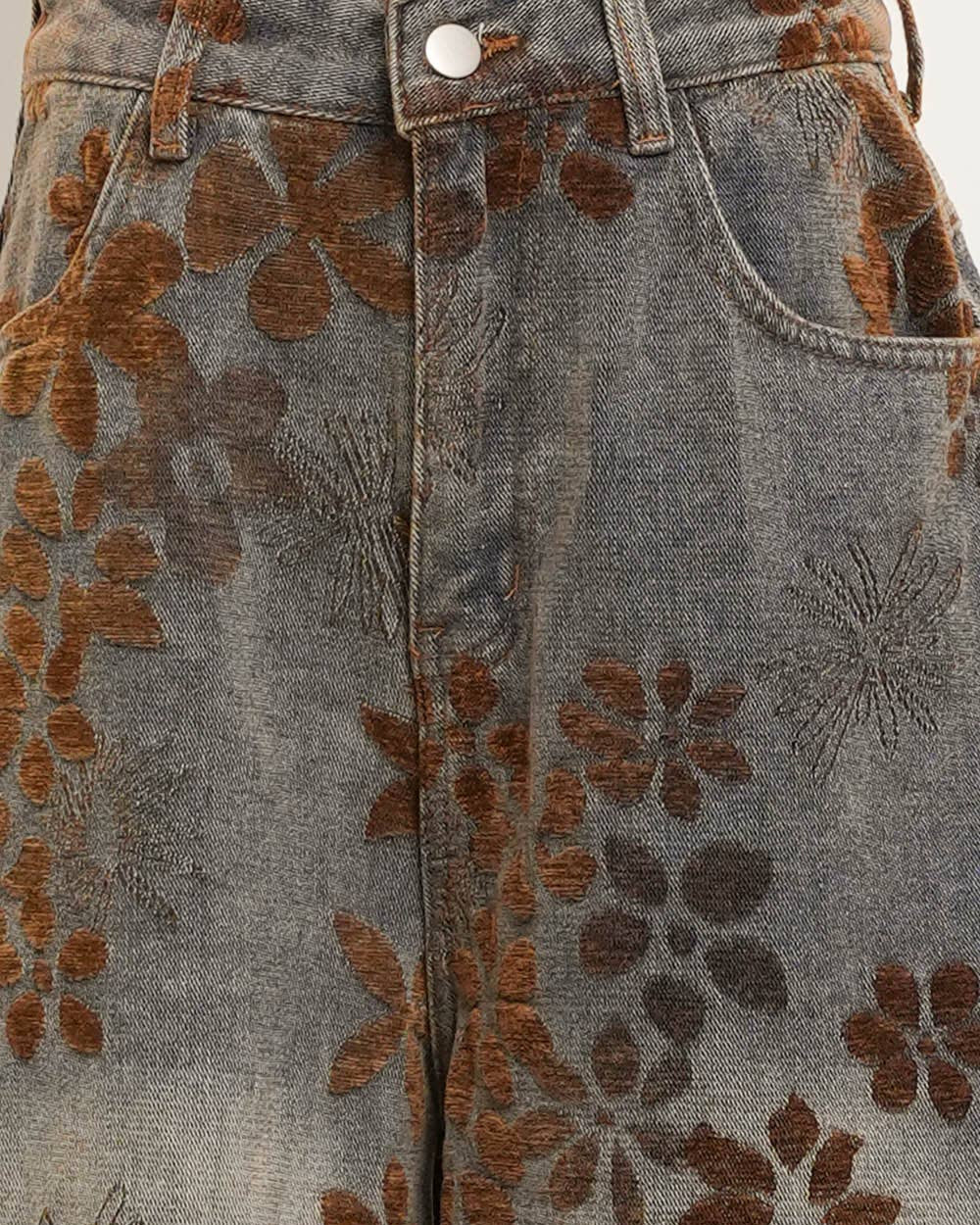 Close-up of denim fabric with brown floral embroidery