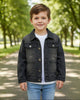 Toddler wearing a black acid wash denim jacket from Calla Lily Cosmetics + CL kids in a park setting.