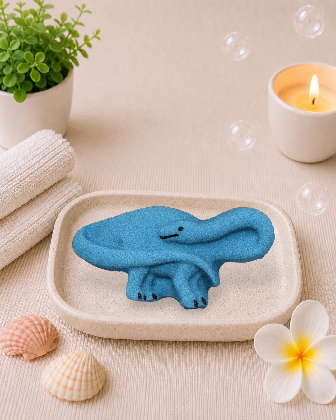 Calla Lily Cosmetics + CL kids blue brontosaurus shaped bath bomb with blood orange scent on white wood background