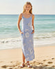 Girl wearing a Calla Lily Cosmetics + CL kids blue floral sleeveless maxi dress with side slits on a sunny beach.