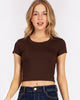 Model wearing a brown Calla Lily Cosmetics + CL kids Rosio cropped baby t-shirt with a round neck and junior fit.