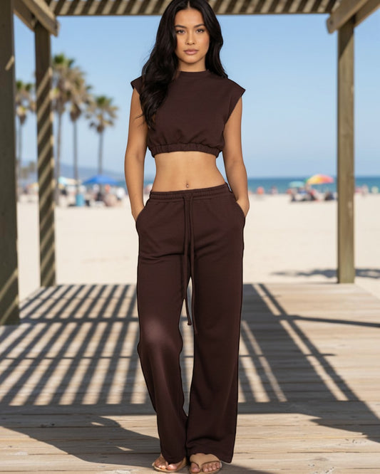 Model wearing Calla Lily Cosmetics + CL kids brown cotton French terry crop top and wide-leg pants set at the beach.