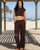 Model wearing Calla Lily Cosmetics + CL kids brown cotton French terry crop top and wide-leg pants set at the beach.