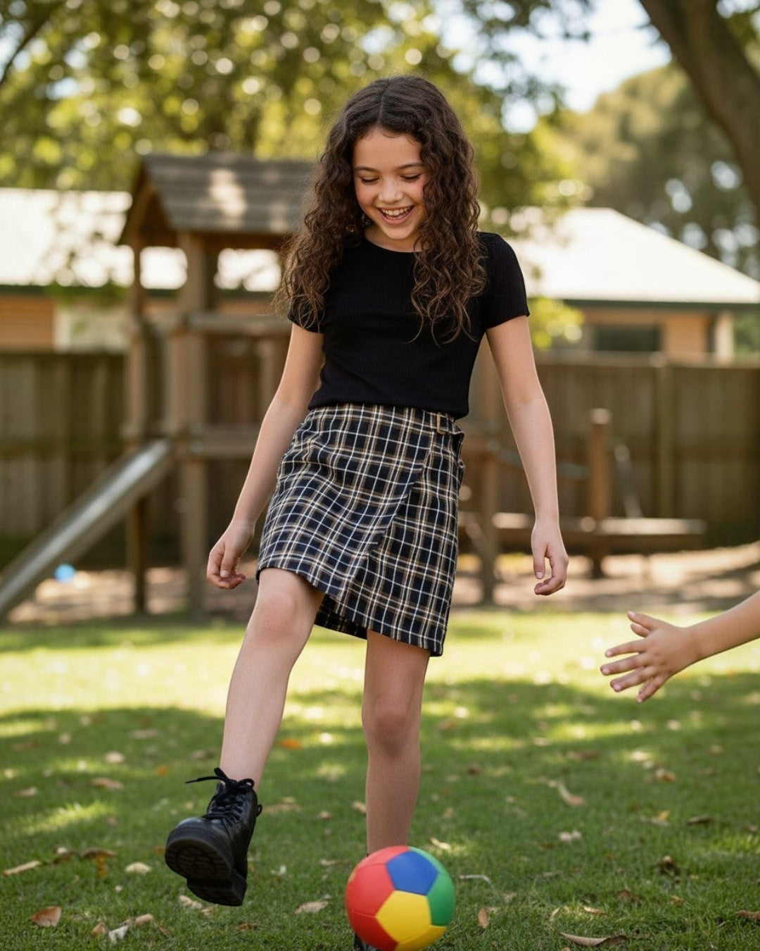 Calla Lily Cosmetics + CL kids brown plaid skirt with side buckle on a girl playing soccer in a park.