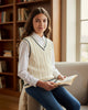 Girl wearing a cream cable knit sweater vest by Calla Lily Cosmetics + CL kids, layered over a white shirt.