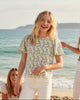 Calla Lily Cosmetics + CL kids green floral flutter sleeve cropped top worn by a girl on a sunny beach with friends.