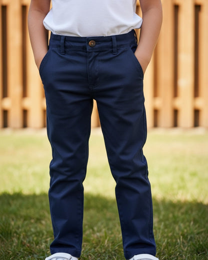 Child wearing Calla Lily Cosmetics + CL kids navy cotton-spandex pants with button fly and pockets outdoors.