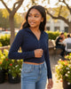 Model wearing a navy French Terry crop zip-up hoodie by Calla Lily Cosmetics + CL kids in an outdoor setting.