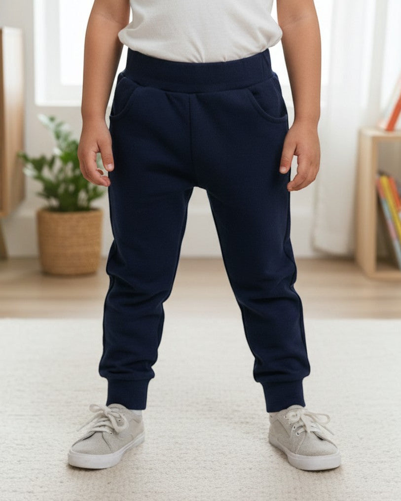 Child wearing Calla Lily Cosmetics + CL kids navy cotton-blend joggers with front pockets in a bright room.