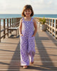 Girl wearing a light purple floral rayon romper with a smocked top and side pockets by Calla Lily Cosmetics + CL kids
