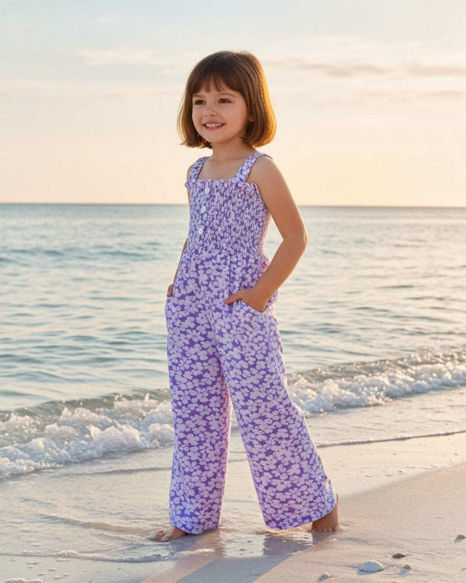 Girl wearing a light purple floral rayon romper by Calla Lily Cosmetics + CL kids on a beach at sunset.