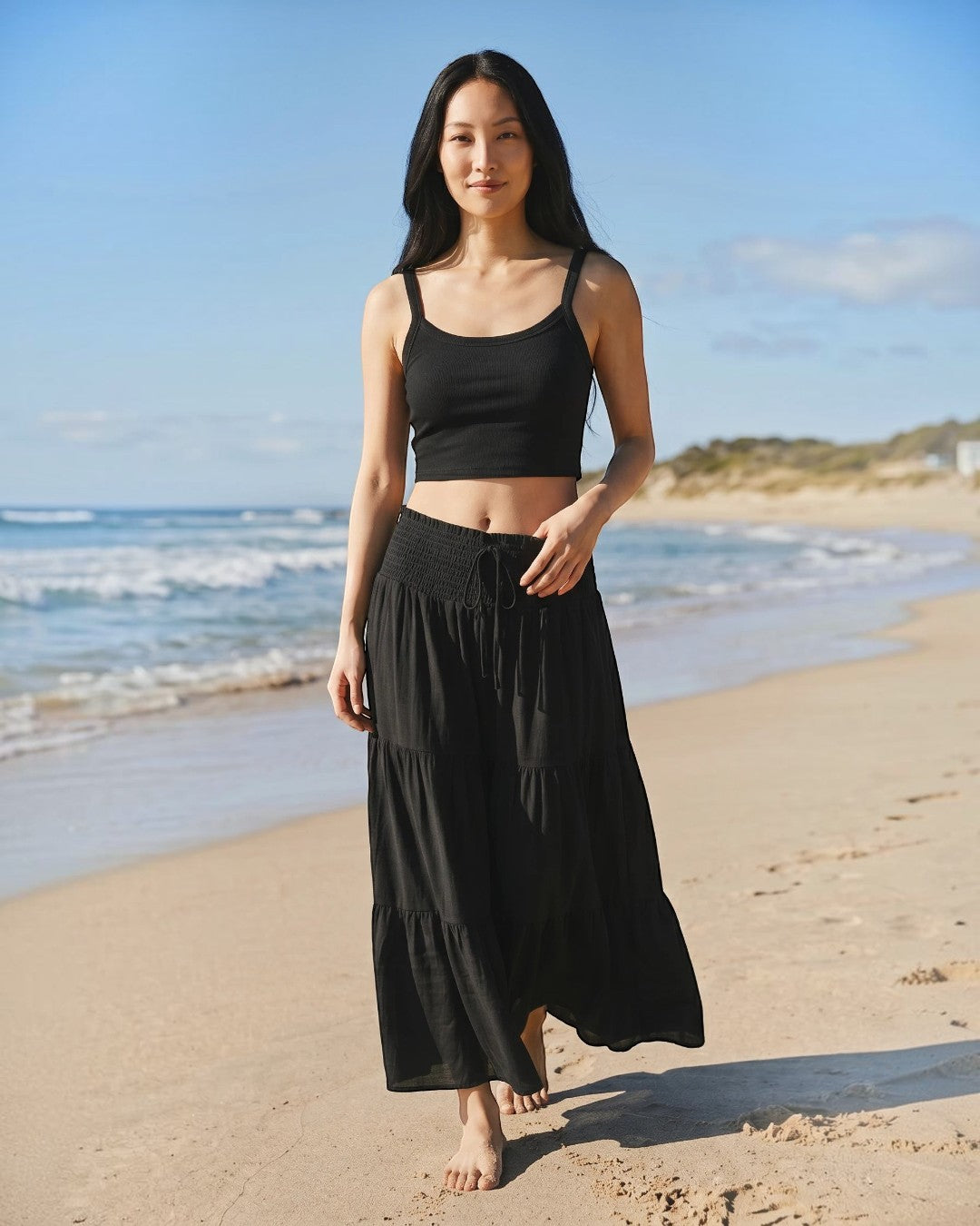 Calla Lily Cosmetics + CL kids black ribbed knit crop tank top worn by a woman on a sunny beach