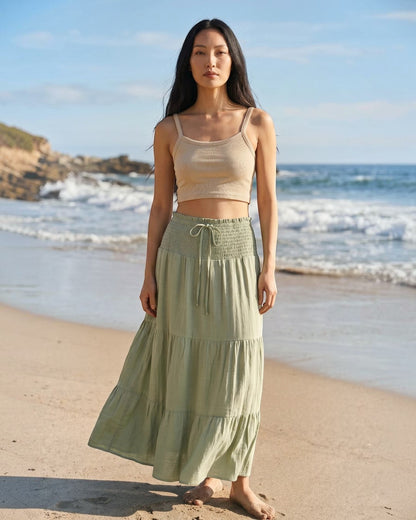 Model wearing a Calla Lily Cosmetics + CL kids ribbed knit beige crop tank top with a sage green tiered maxi skirt.