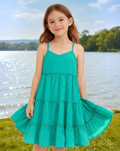Young girl wearing a Calla Lily Cosmetics + CL kids teal tiered maxi dress with spaghetti straps by a lake.