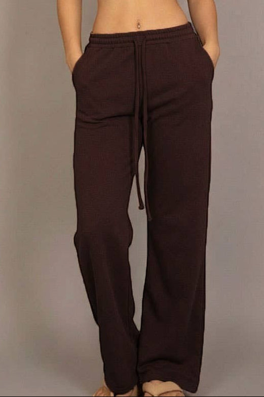 Calla Lily Cosmetics brown cotton French terry crop top with cap sleeves and elastic hem, paired with wide-leg pants.
