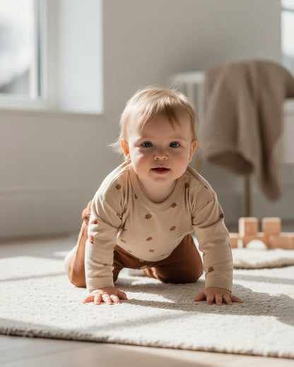 Calla Lily Cosmetics + CL kids beige long-sleeve cotton baby shirt with acorn print and brown pants with button detail.