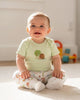 Calla Lily Cosmetics + CL kids 3-pack baby bodysuits and pants in soft cotton. One white sleeveless bodysuit and pants feature a playful insect print. A light green short-sleeve bodysuit has a snail and tree graphic.
