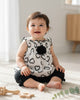 Calla Lily Cosmetics + CL kids white chiffon baby top with black hearts and flower accent, paired with black leggings with bows. 100% polyester.