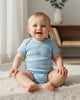 Calla Lily Cosmetics + CL kids light blue 100% cotton short-sleeve baby bodysuit with snap closure.