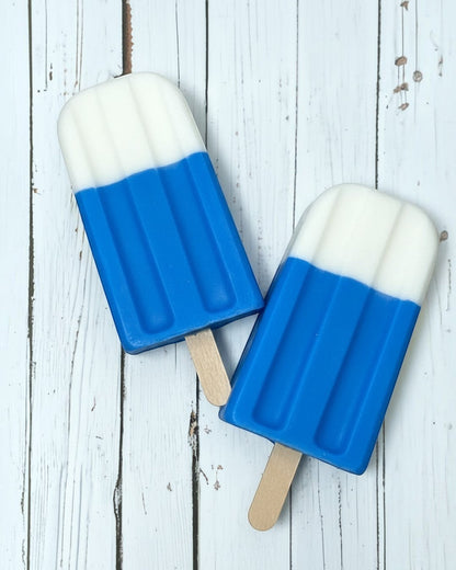 Calla Lily Cosmetics + CL kids blue and white popsicle-shaped shea butter soap on a rustic white wooden background.