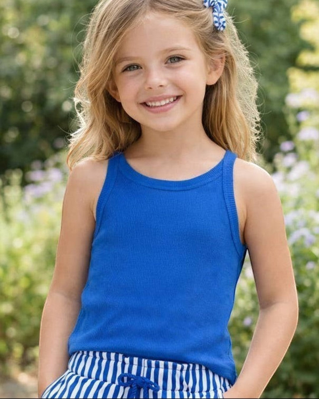 Calla Lily Cosmetics + CL kids blue ribbed cotton tank top and striped shorts on a smiling girl outdoors.