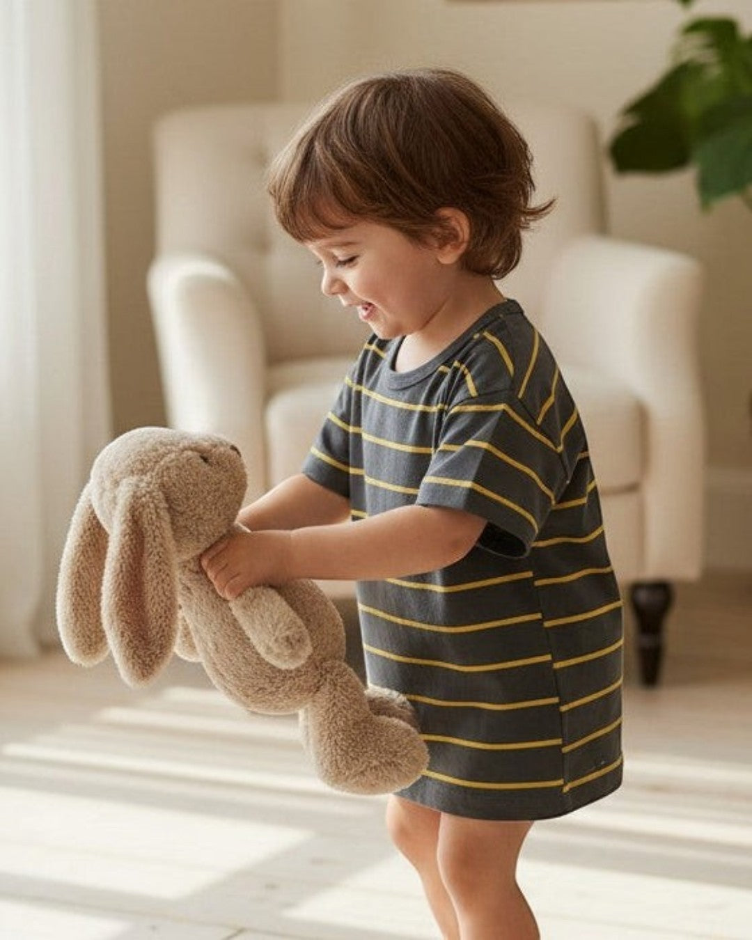 Calla Lily Cosmetics + CL kids boys grey t-shirt with yellow stripes, paired with beige shorts and white sneakers.