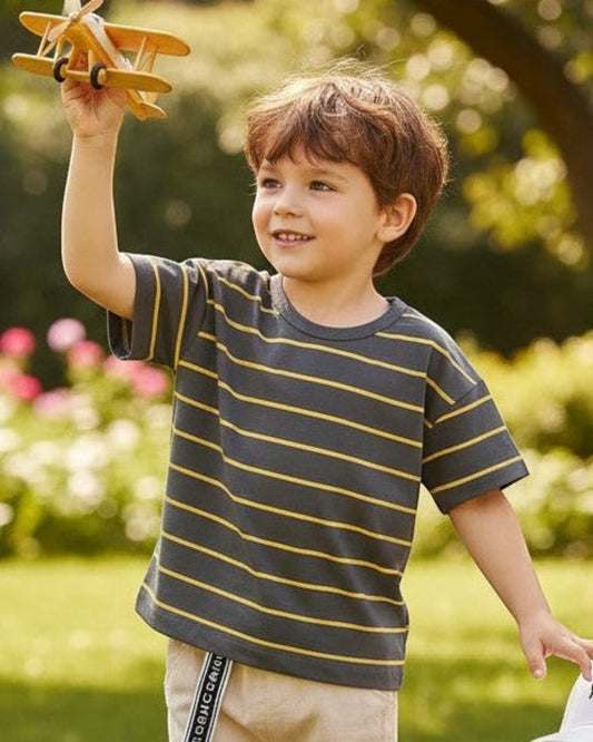 Calla Lily Cosmetics + CL kids boys grey t-shirt with yellow stripes, paired with beige shorts and white sneakers.