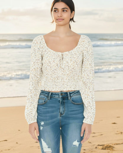 Model wearing Calla Lily Cosmetics + CL kids cream floral peasant crop top with long sleeves and smocked hem at beach