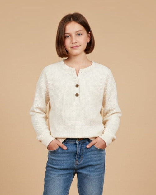 Girl wearing a Calla Lily Cosmetics + CL kids cream thermal waffle knit Henley with a three-button placket and jeans.