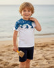 Calla Lily Cosmetics + CL kids white cotton t-shirt with blue dinosaur graphic and navy shorts. Features 3D spikes on shoulders.