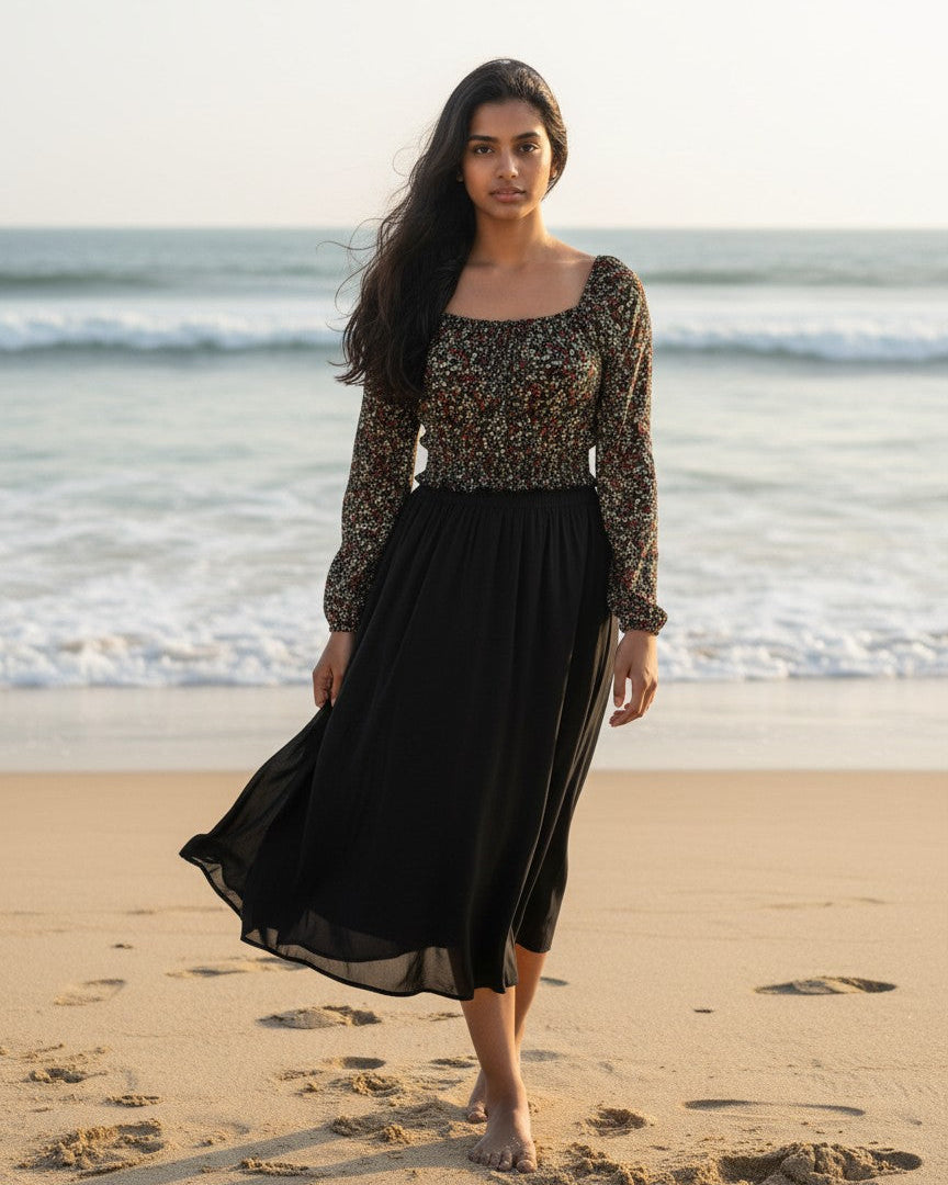 Model wearing a Calla Lily Cosmetics + CL kids black floral long sleeve peasant crop top with a matching midi skirt.
